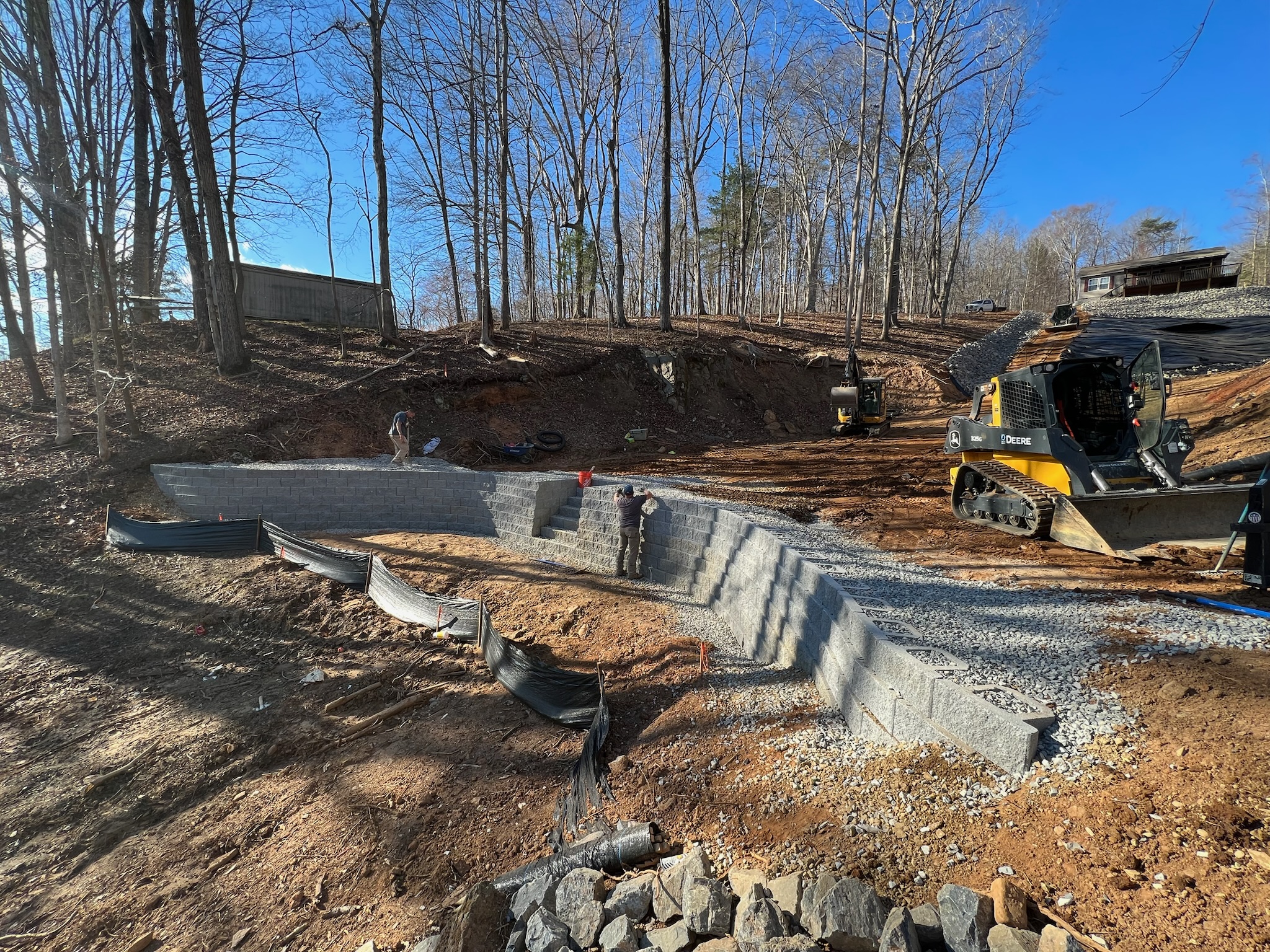 Retaining wall construction in progress with equipment on site