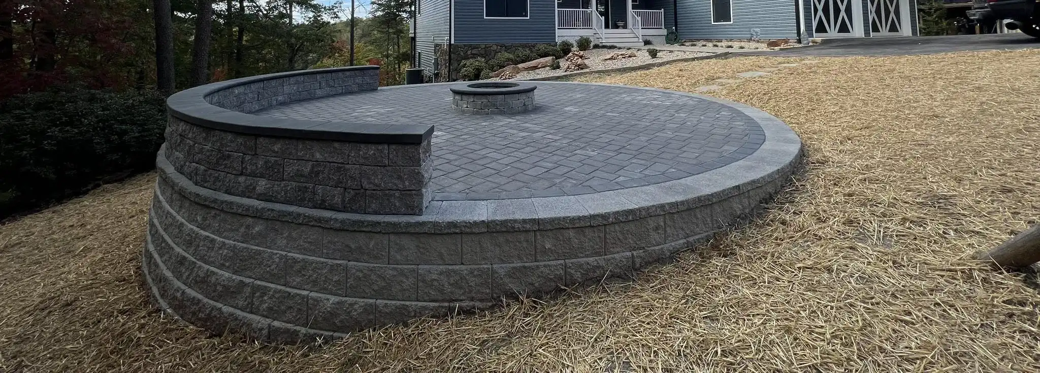 Circular paver patio with integrated sitting wall and fire pit